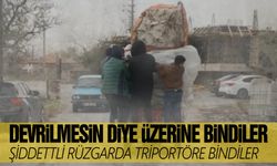 Şiddetli rüzgarda triportör devrilmesin diye üzerine binip gittiler